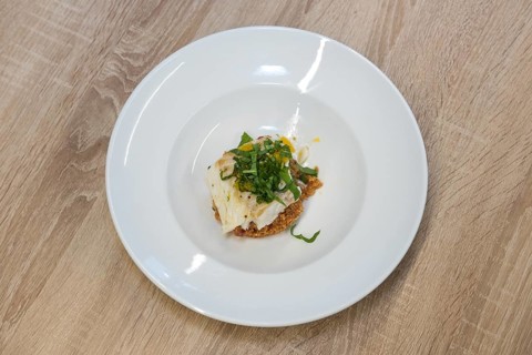 Top view of fried white fish fillet with quinoa porridge on wooden table