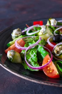 Fresh salad with zucchini stuffed with feta cheese with tomato