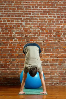 Athletic man doing exercises for the balance on rubber ball. Fitness workout