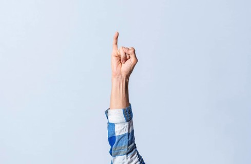 Hand gesturing the letter I in sign language on an isolated background. Man's hand gesturing the letter I of the alphabet isolated. Letters of the alphabet in sign language