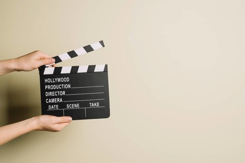 Crop hands with clapperboard