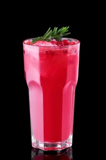 Glass of cranberry juice with crushed ice isolated on black background