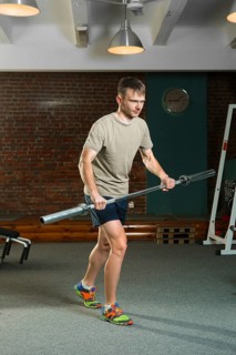 Triathlon sportsman rowing with barbell. Fitness workout
