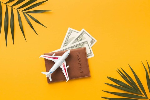 Flat lay passport with money plane figurine top