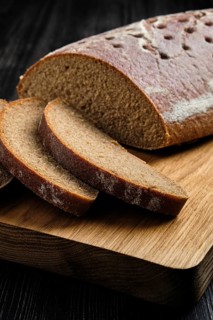 Close up view of yeast-free brown bread on wooden cutting board
