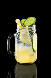Cold fruit lemonade in mason jar isolated on black background