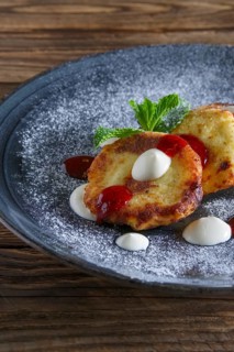 Cheese pancakes served with sour cream and strawberry jam