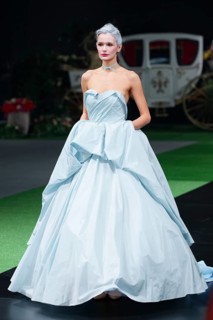 Fashion model in long designers dress walking on runway