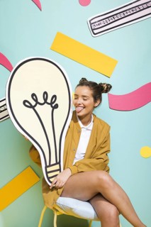 Portrait schoolgirl with big light bulb