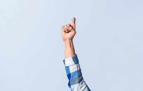 Hand gesturing the letter Z in sign language on an isolated background. Man's hand gesturing the letter Z of the alphabet isolated. Letter Z of the alphabet in sign language