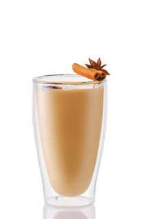 Hot milk winter drink with cinnamon and anise in double wall glass
