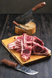 Raw lamb rib chops on wooden cutting board