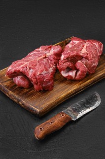 Raw rolled lamb boneless neck meat on cutting board
