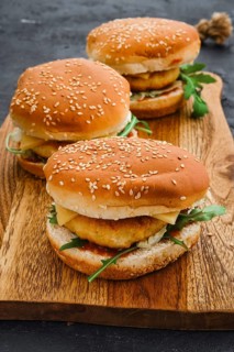 Homemade burger with chicken cutlet on long wooden board