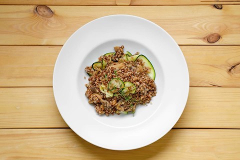 Overhead view of boiled buckwheat with marinated mushrooms and fresh cucumber