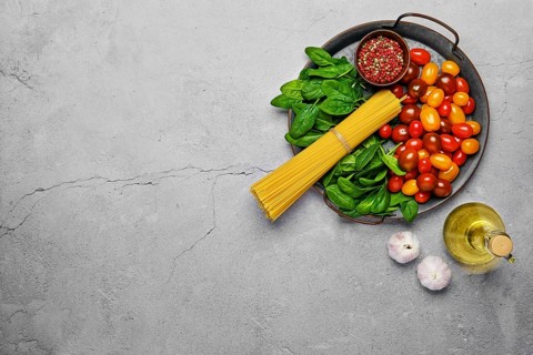 Overhead view of a bunch of raw spaghetti with spinach