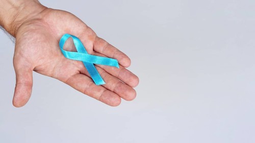 Close up hand holding blue ribbon