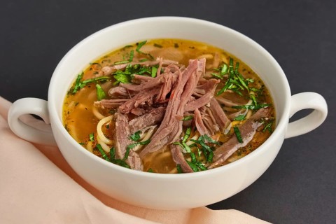 Plate of beef soup with pieces of meat