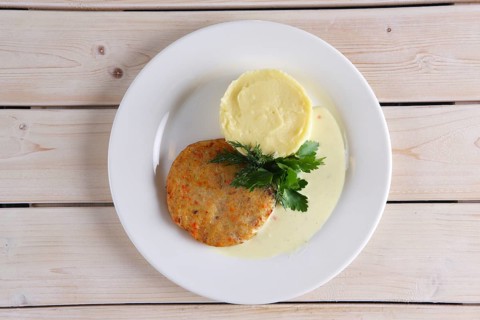 Top view of fish cutlet with mashed potato on wooden table