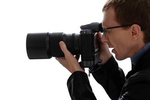 Close up portrait of photographer with camera on white background