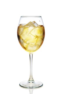 Apple cocktail with a sparkling wine with ice cubes in wine glass isolated on white