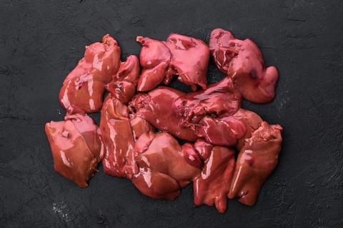Top view of raw duck liver on black concrete background
