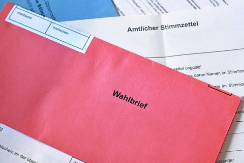 Red German postal voting envelope with German text saying 'voting letter' on ballot paper