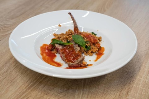 Fried lamb rib with quinoa porridge on wooden table