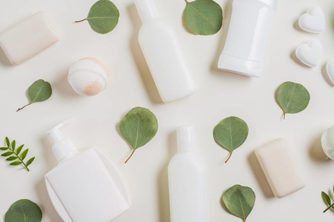 Overhead view cosmetics products soap bath bomb green leaves