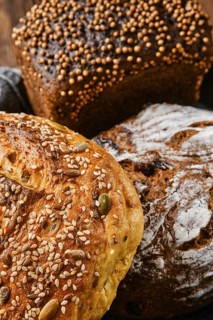 Closeup view of assortment of cereal bread made of different seeds on wooden table