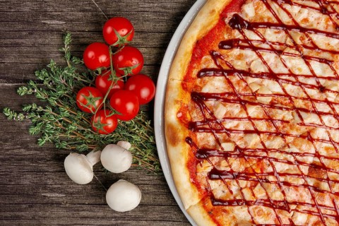 Pizza with barbecue sauce and ingredints on wooden table