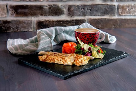 Omelette with salmon on slate plate and cup of latte