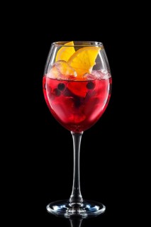 Cold sangria in a wine glass isolated on black background