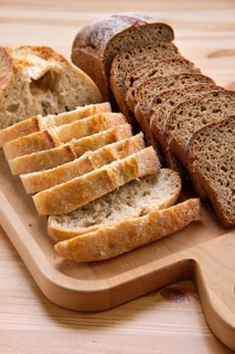 White and brown bread on wooden cutting board