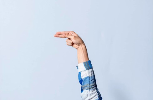Hand gesturing the letter H in sign language on an isolated background. Man's hand gesturing the letter H of the alphabet isolated. Letters of the alphabet in sign language