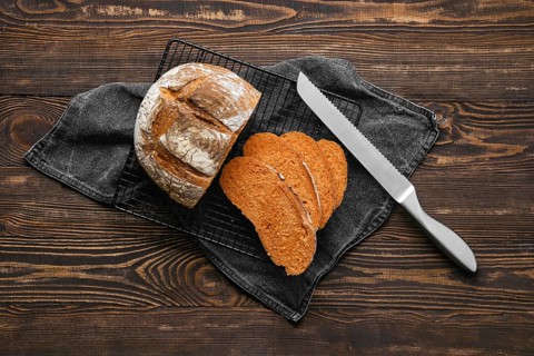 Overhead view of artisan whole grain tomato wheat bread cut on slices on wooden table