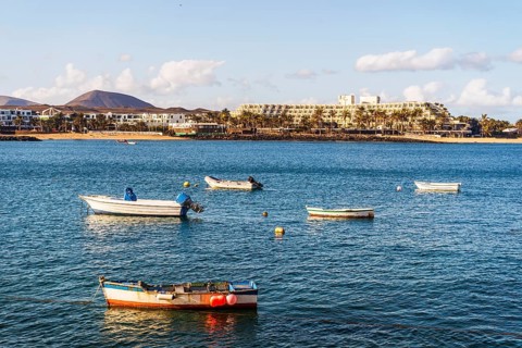 View of the resort town named Costa Teguise with boats on the foreground