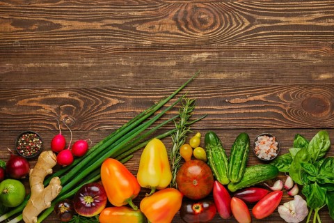 Top view of wooden background with different types of vegetables