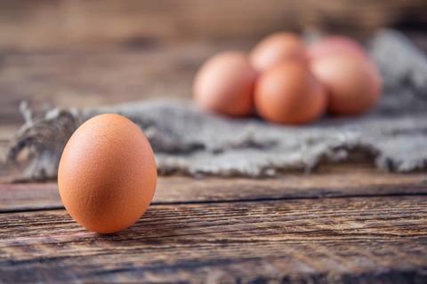 Close up view of brown chicken eggs on wooden table