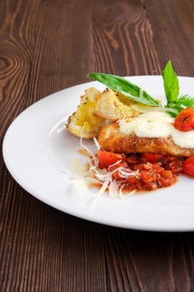 Closeup view of roasted chicken fillet with tomato cherry