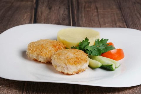Plate with salmon cutlet with mashed potato and fresh cucumber and tomato