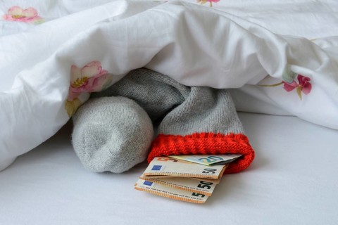 Banknotes in stocking under duvet