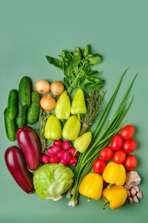 Fresh vegetables scattered on pale green background