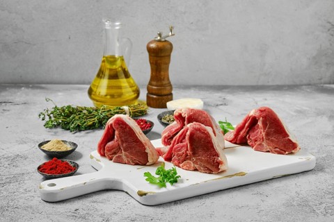 Uncooked boneless rack of lamb on cutting board
