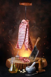 Poster with raw lamb ribs on hook over wooden stumb
