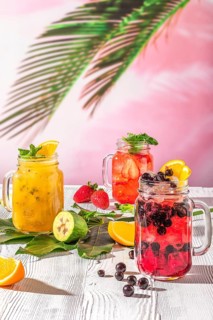 Summer fruit lemonades on white wooden table in Mason jar