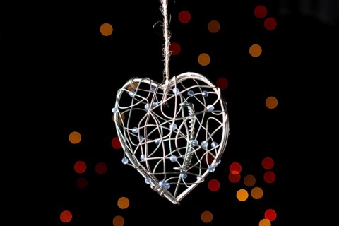 Heart shaped metal cage on a bokeh light background