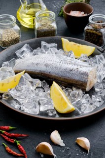 Frozen raw pollock carcass on wooden background