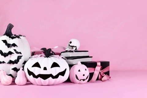 Pink Halloween decor with pink and black and white pumpkins and copy space
