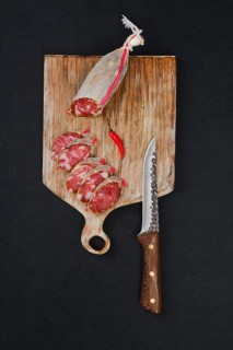 Top view of sliced dry beef sausage on cutting board